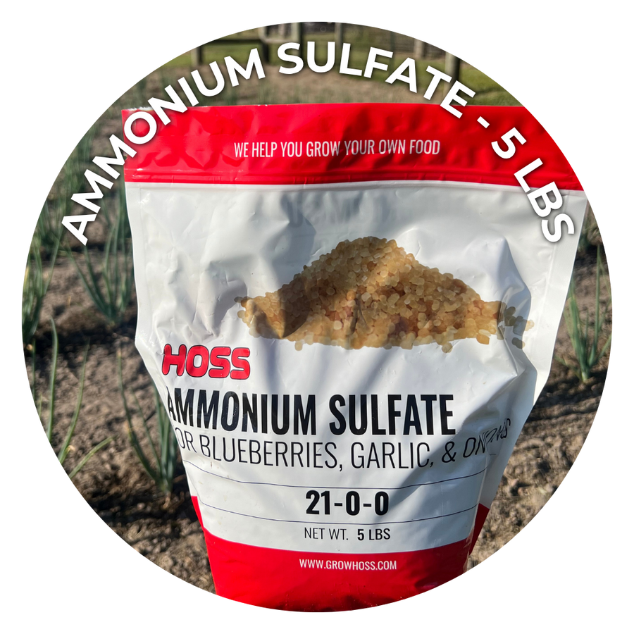 A circular product photo of a 5 lb bag of Hoss Ammonium Sulfate fertilizer, shown against a blurred outdoor garden background. The bag is white with red top and bottom bands, and black text.