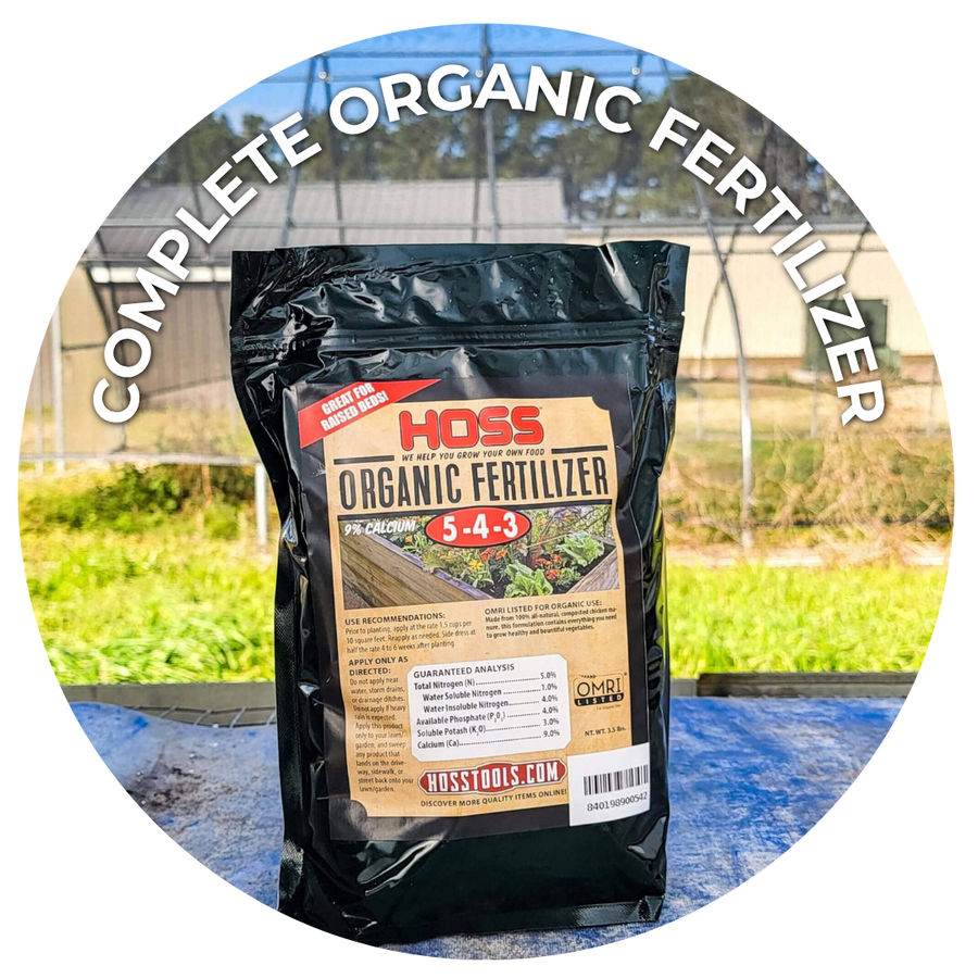 Hoss Complete Organic Fertilizer 5-4-3: a black bag of Hoss Organic Fertilizer on a table in front of a greenhouse.