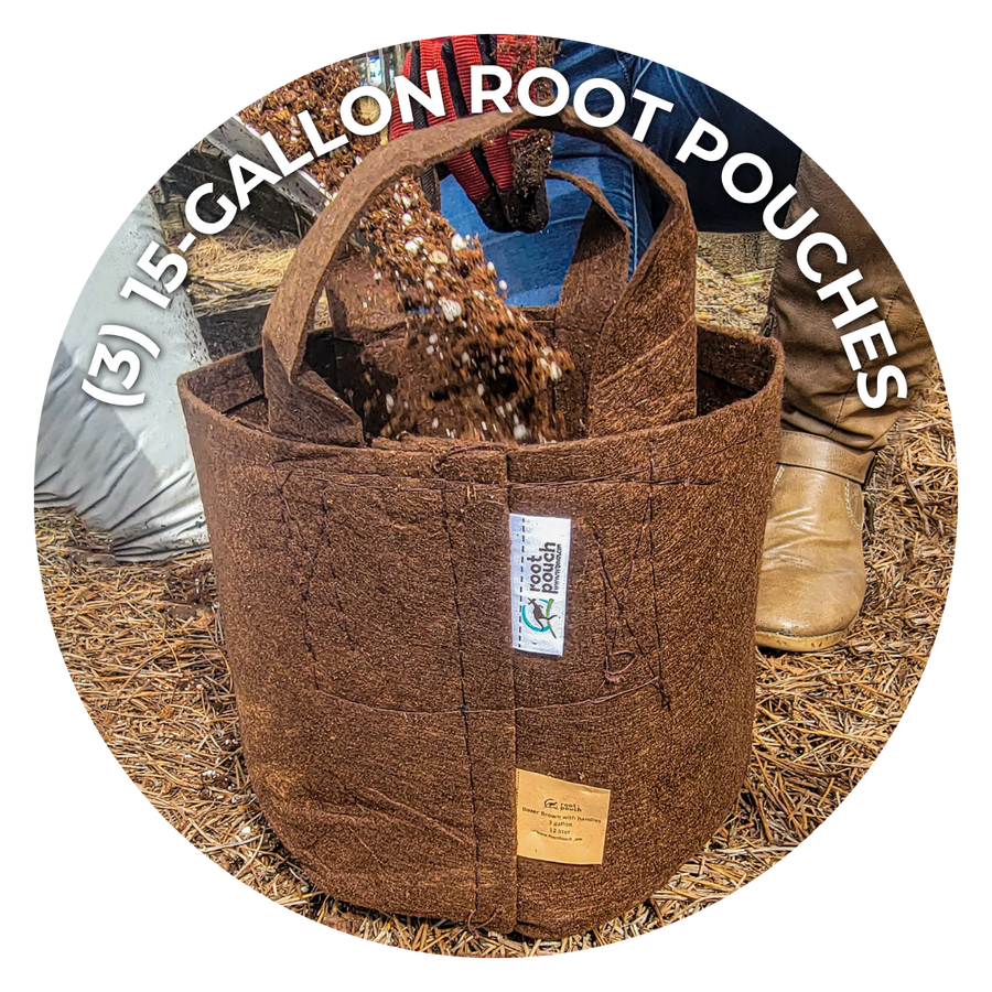 A brown coir fabric root pouch with a handle, shown outdoors on straw with a person's legs and boots partially visible behind it. White curved text at the top reads '(3) 15 GALLON ROOT POUCHES'.